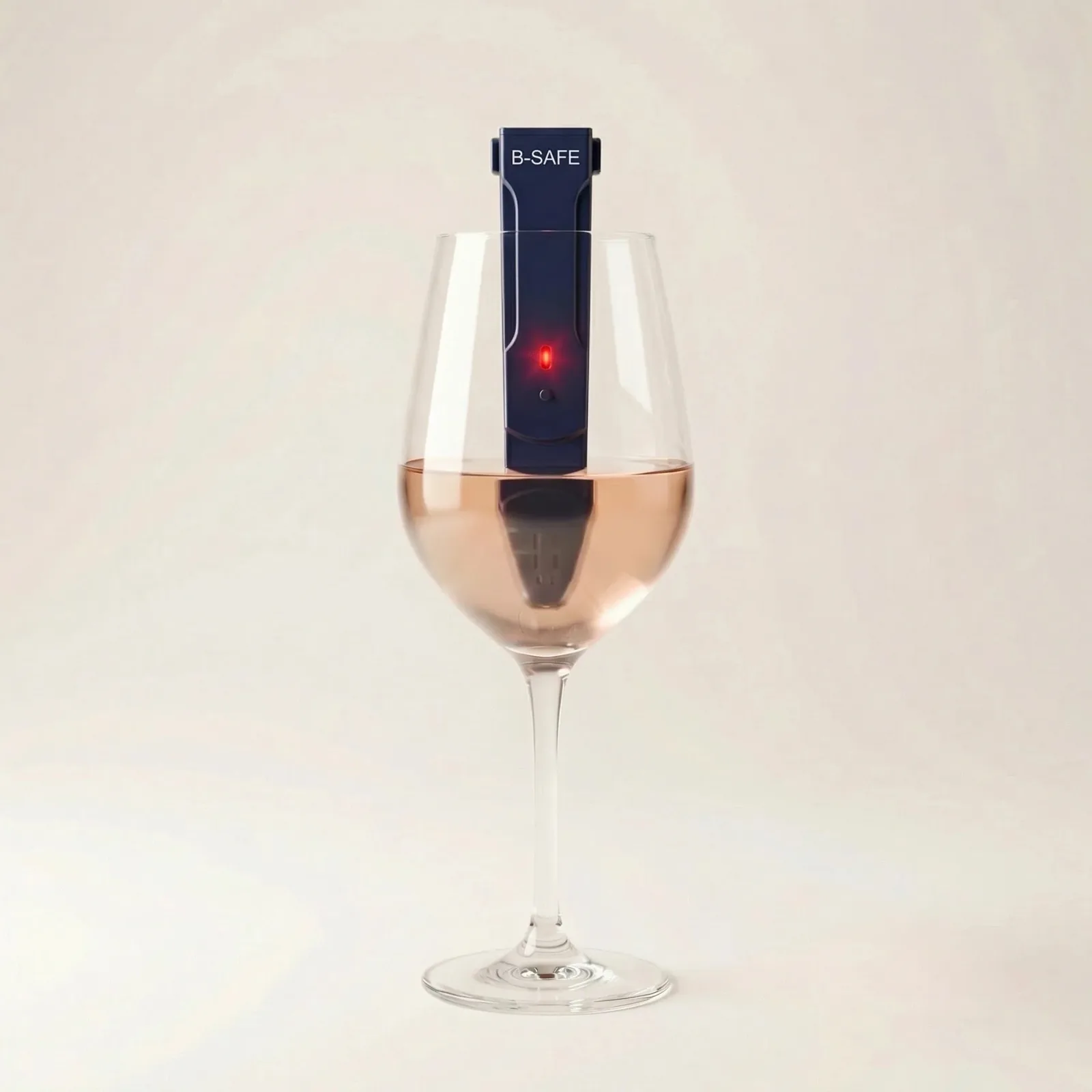 Verre B-Safe présenté le 14 juin 2026, gobelet en verre transparent dont le bord supérieur intègre une bande circulaire de réactif chimique qui change de couleur du vert au rouge en présence de GHB ou de kétamine, ambiance bar tamisé avec pyramide de verres en arrière-plan, dispositif conçu pour la prévention des soumissions chimiques en milieu festif