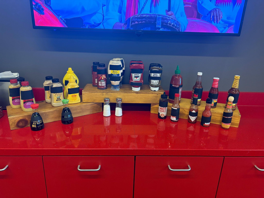 Édition spéciale Heinz Clean Bottle dévoilée le 20 juin 2026 par Saatchi Saatchi, bouteille de ketchup Heinz emblématique en plastique transparent rempli de sauce rouge tomate, étiquette frontale entièrement imprimée d'une fausse bande de scotch noir mat