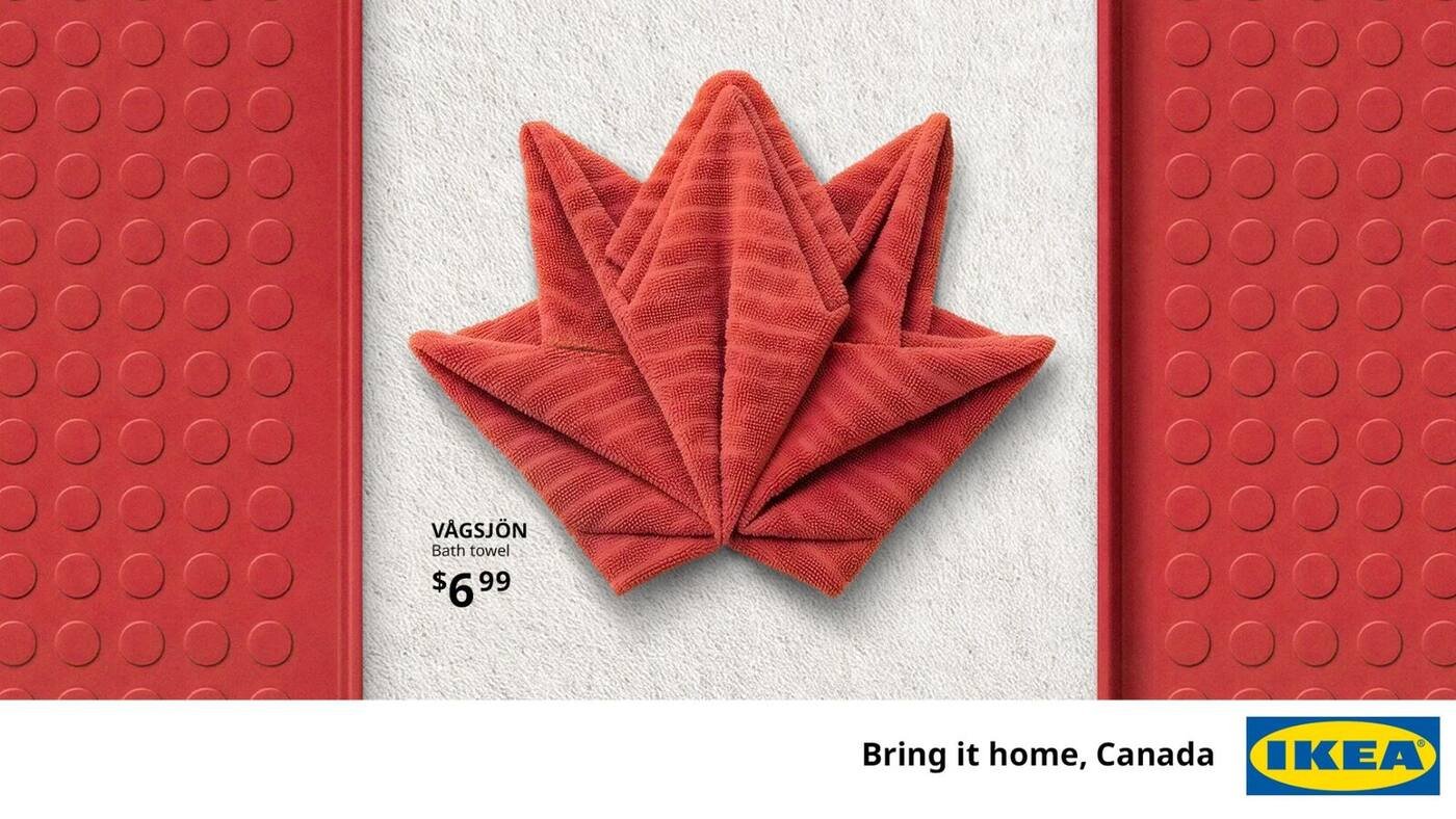 Visuel principal de la campagne IKEA Canada Assemble the World dévoilée le 17 juin 2026, drapeau du Canada reconstitué intégralement avec deux serviettes de bain Vågsjön rouges modèle 6,99 dollars, pliées en éventail pour former la feuille d'érable centrale sur fond crème, encadrement à gauche et à droite par des tapis plastique rouges à picots Vågsjön style cour de récréation, mention prix VÅGSJÖN Bath towel 6,99 dollars en bas à gauche, signature Bring it home Canada et logo IKEA jaune sur fond bleu en bas à droite