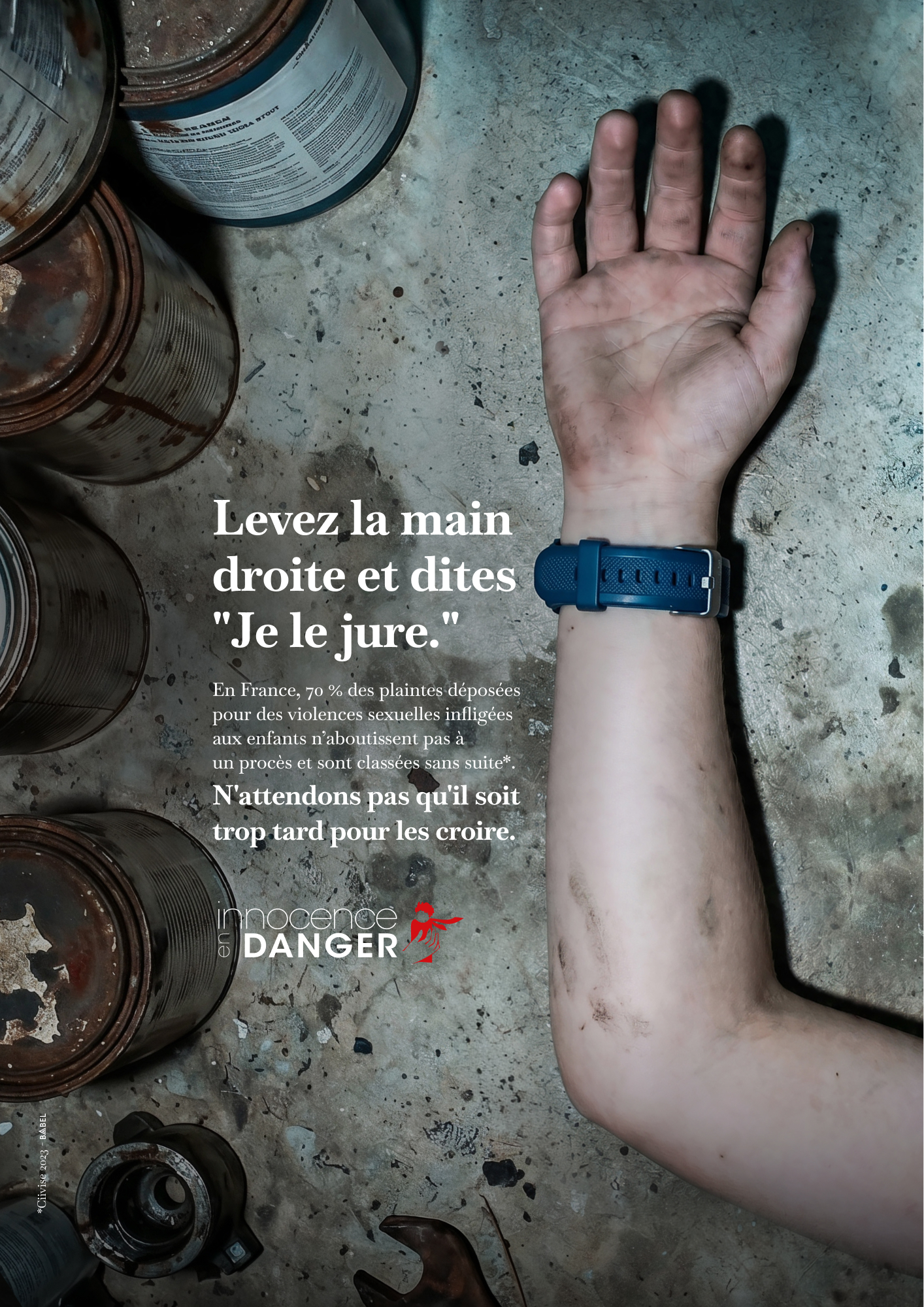 Deuxième visuel de la campagne Innocence en Danger Babel du 18 juin 2026, plan large d'une chambre d'enfant abandonnée à la lumière froide d'un matin gris, peluche en gros plan sur un parquet brut taché de poussière et de débris de plâtre, accroche manuscrite rouge Levez la main droite et dites Je le jure en haut du visuel, signature en bas N'attendons pas qu'il soit trop tard pour les croire, logo association en bas à droite