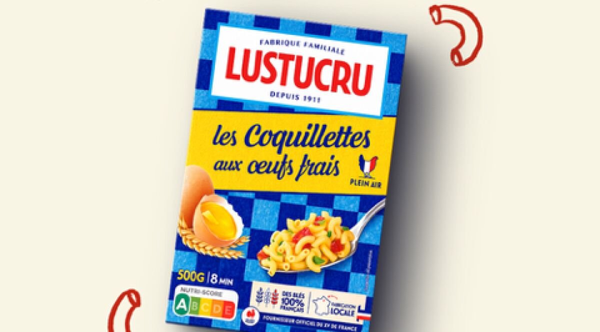 Visuel principal de la nouvelle campagne Lustucru signée Foolish dévoilée le 17 juin 2026, paquet de Coquillettes aux œufs frais Lustucru en biais sur fond crème pâle, design rétro bleu marine et rouge brique typique de la marque, mention Fabriqué en France Depuis 1911 en haut, croquis manuscrits de pâtes rouges en arc de cercle et flèche au-dessus du paquet, signature populaire et complice fidèle à l'ADN Lustucru