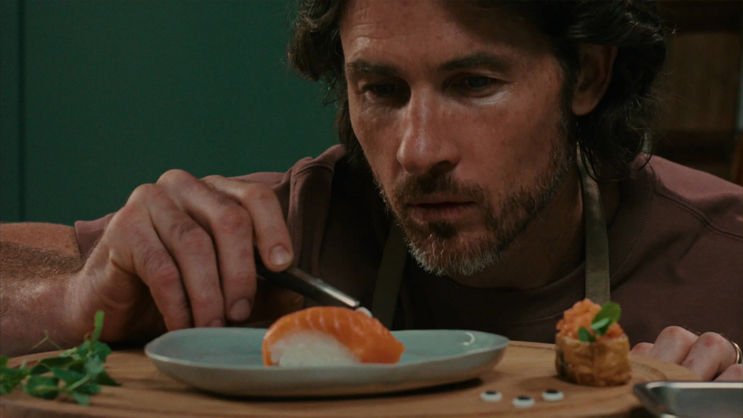 Migros campagne d'été 2026 signée thjnk Zürich, spot TV avec deux papas qui se livrent un duel culinaire silencieux pour leurs enfants, série de visuels où le bacon devient un feu de camp, les sushis des fleurs et la carotte une voiture de course, juin 2026