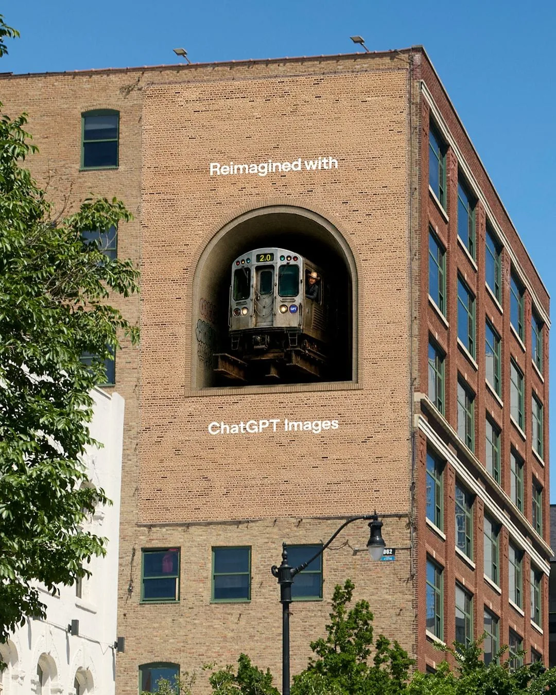 Deuxième affichage en trompe-l'oeil de la campagne OpenAI Reimagined with ChatGPT Images déployée le 15 juin 2026, façade d'immeuble en briques rouges typique de Chicago percée d'une niche arquée d'où sort la cabine avant d'un train de métro élevé Chicago avec sa peinture rouge et bleue caractéristique, slogan ChatGPT Images écrit en blanc en dessous du tunnel illusoire