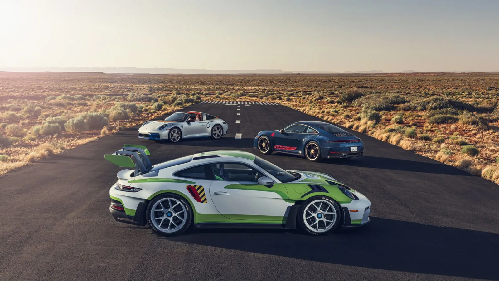 Trois Porsche 911 customisées par l'atelier Sonderwunsch dévoilées le 13 juin 2026 au Dolby Theatre pour la première mondiale de Toy Story 5, à gauche une 911 GT3 RS pack Weissach aux couleurs de Buzz l'Éclair vert et violet avec aileron arrière déployé, au centre une Carrera T bleu denim délavé en hommage à Woody, à droite une Targa 4 GTS rouge vermillon style cheval Jessie posées en cercle sur le tapis rouge