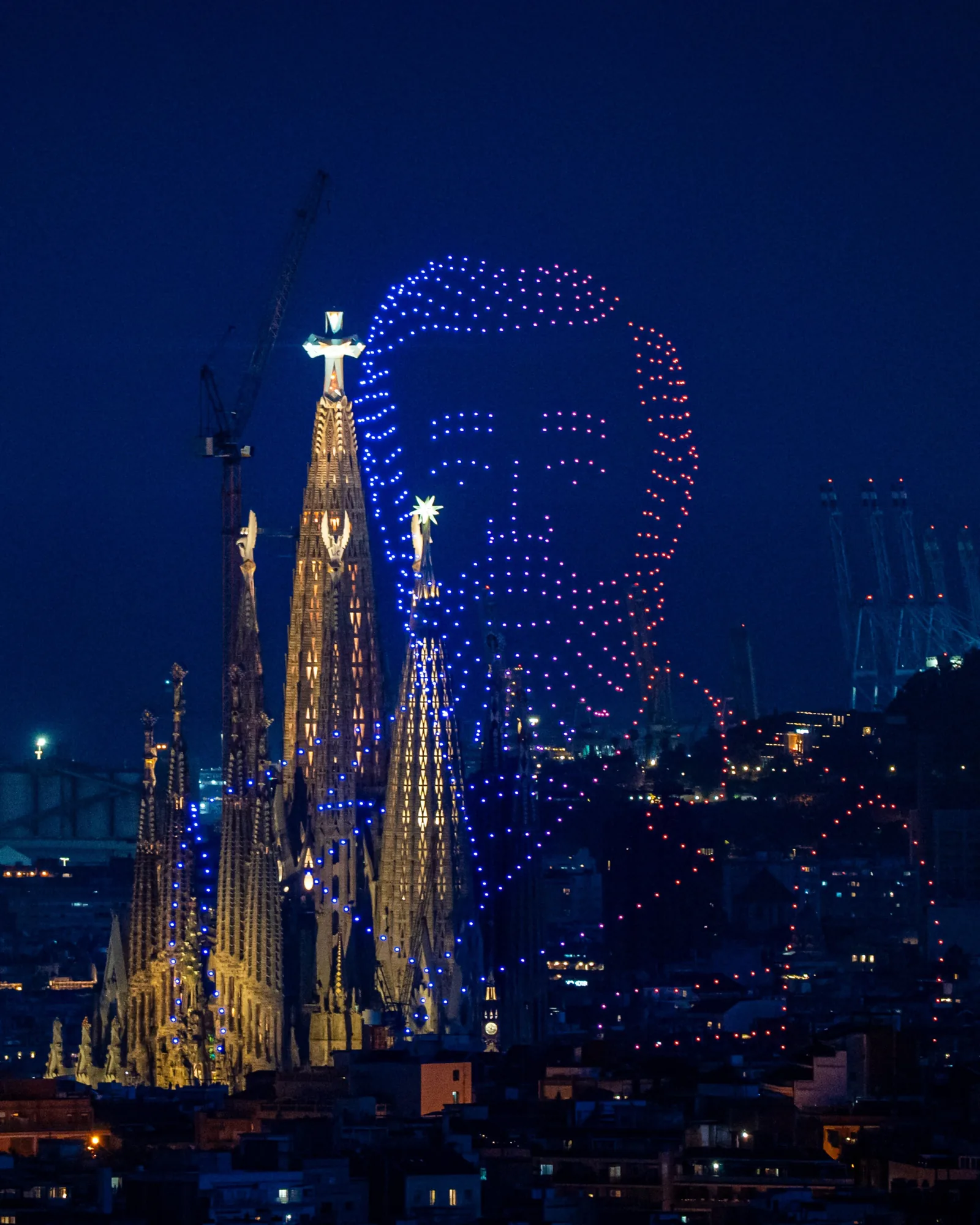 Spectacle de drones organisé le 13 juin 2026 au-dessus de la Sagrada Família à Barcelone pour le centenaire de la mort d'Antoni Gaudí, 700 drones assemblent le visage de profil de l'architecte catalan dans le ciel nocturne, en arrière-plan les flèches éclairées de la basilique encore en chantier et la tour de Jésus inaugurée le même jour à 172,5 mètres de hauteur